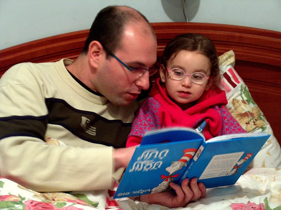 A child reading a calming bedtime story in dim light