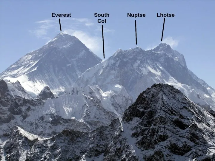 A climber high on a snowy mountain wearing an oxygen mask