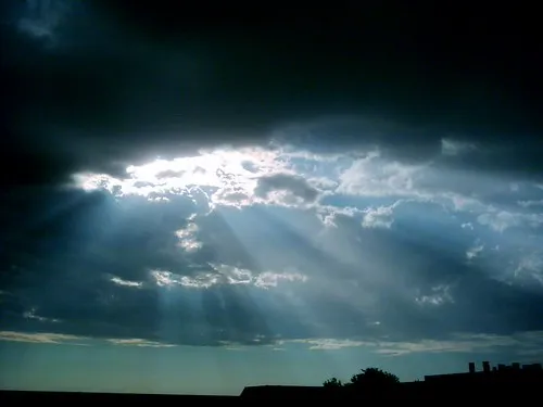 A dramatic sky with both bright sunshine and dark rain clouds