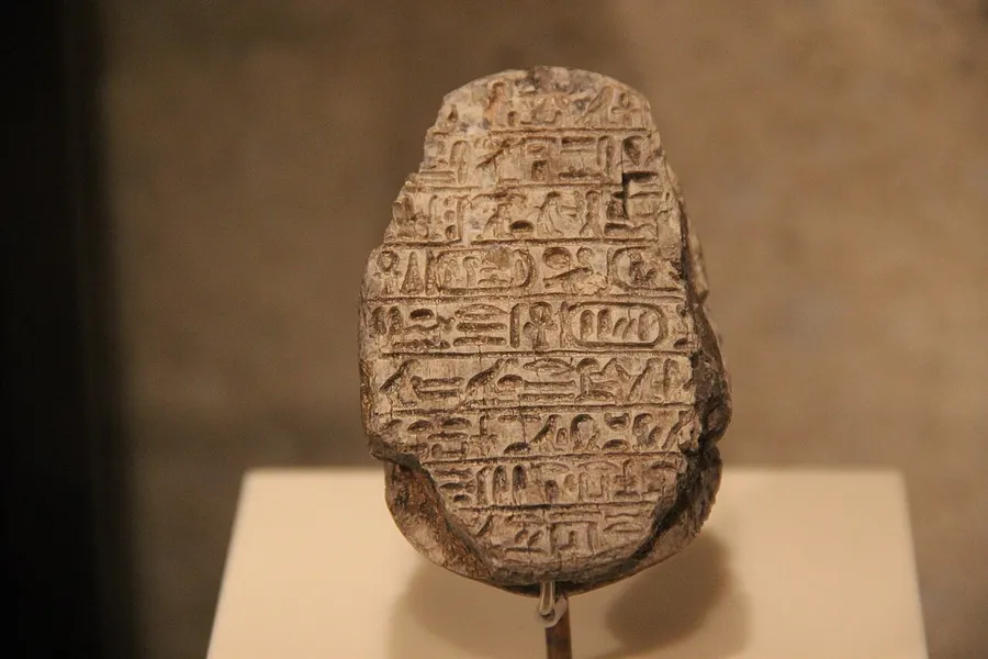 Rows of carved Egyptian hieroglyph picture-symbols on a temple wall