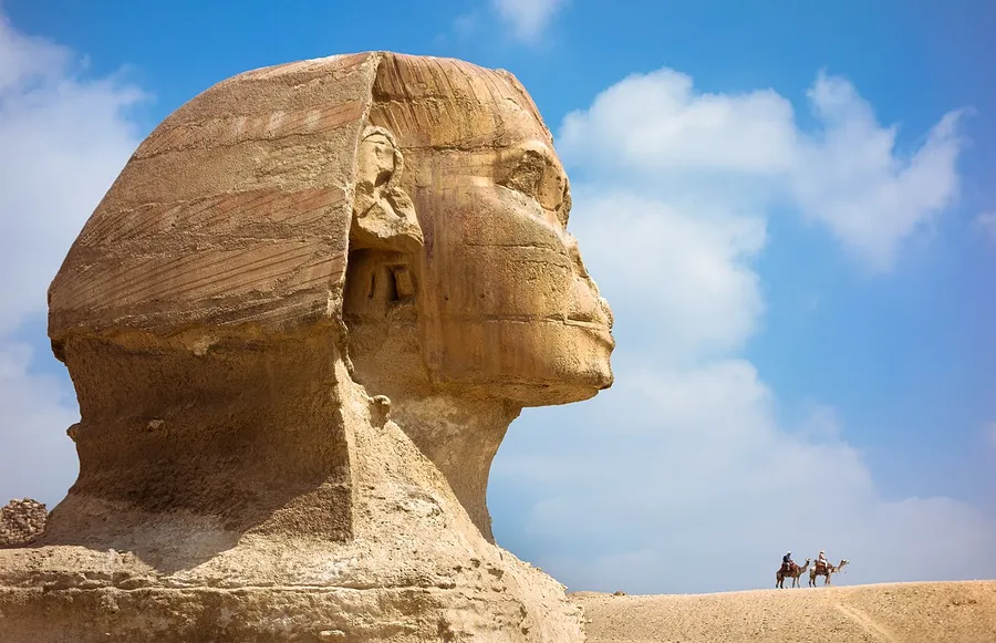 The Great Sphinx of Giza, a giant statue with a lion's body, beside the pyramids