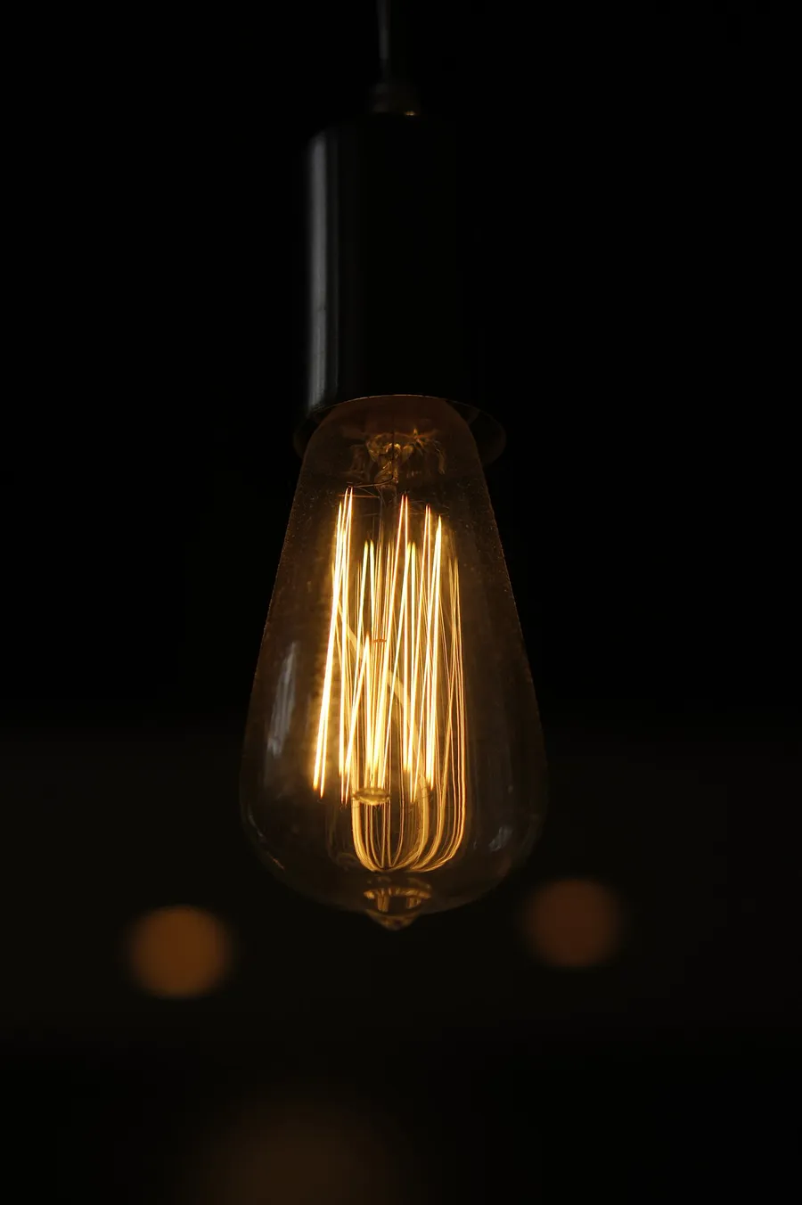 A vintage electric light bulb glowing with a warm filament