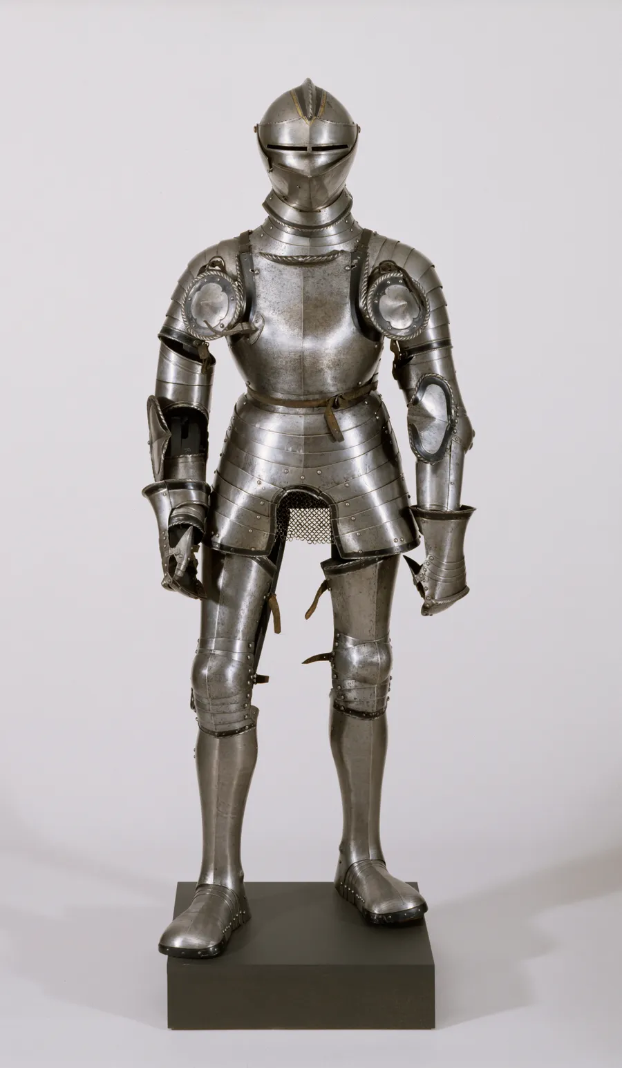 A full suit of shining metal knight's armour on display in a museum