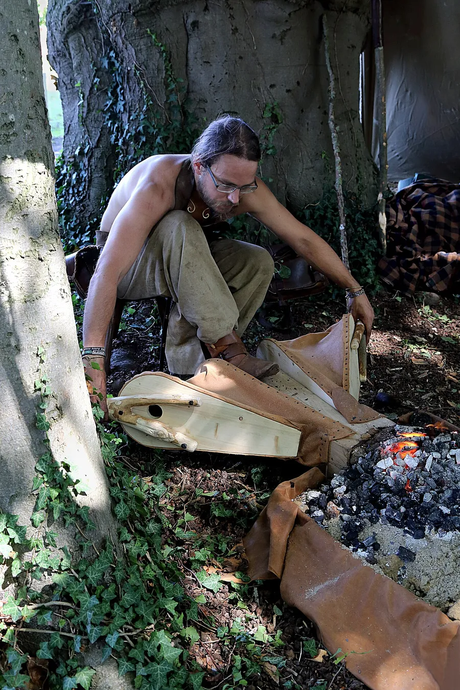 A medieval blacksmith hammering iron at a glowing forge