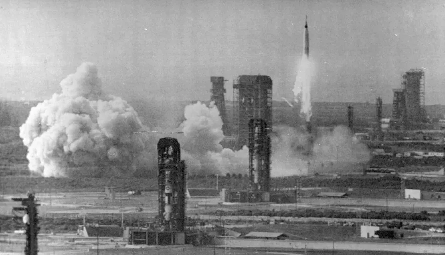 A tall rocket lifting off during the space race