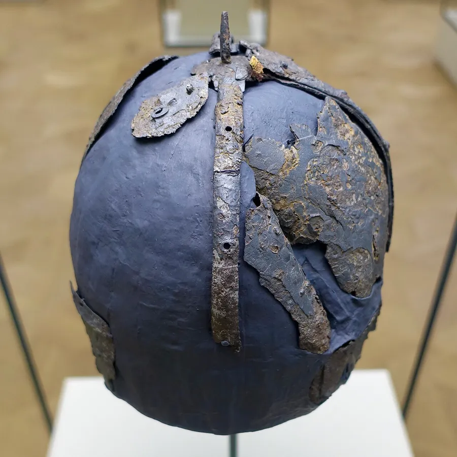 A simple rounded iron Viking helmet displayed in a museum