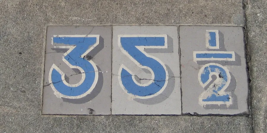 Wooden number tiles lined up in hundreds, tens and units columns