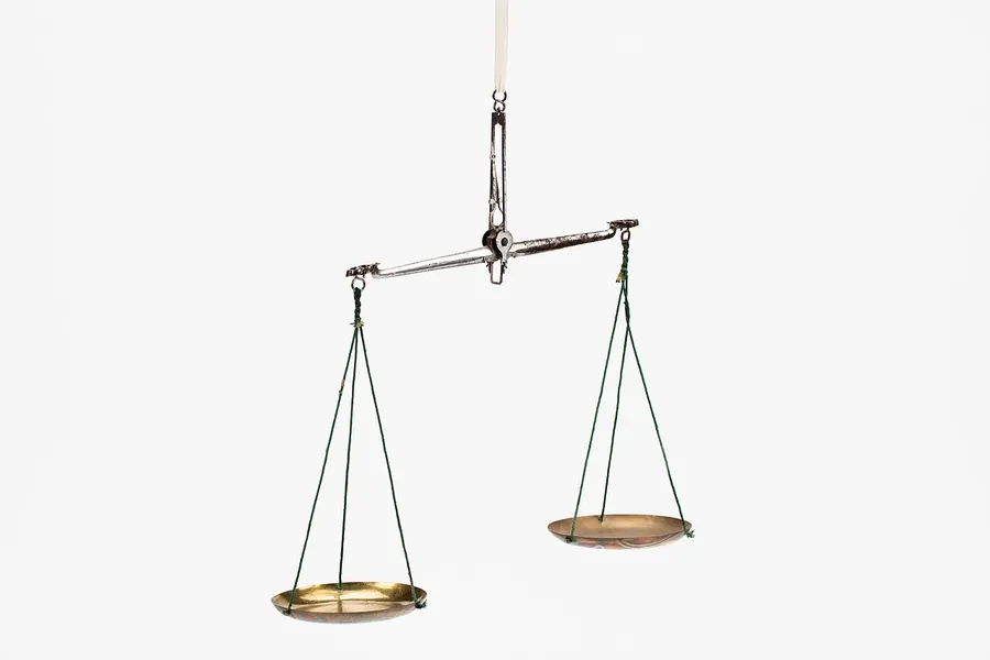 A balance scale with weights used to measure mass in grams