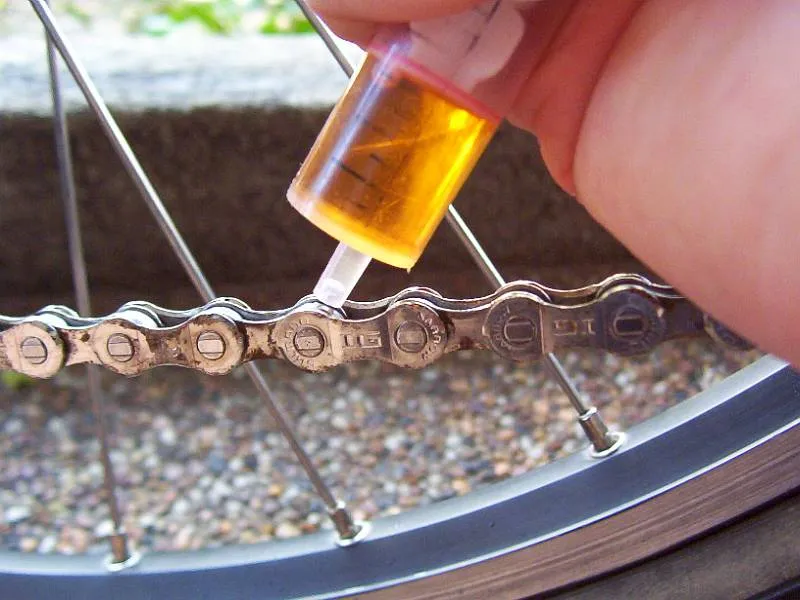 Oil being applied to a bicycle chain to reduce friction