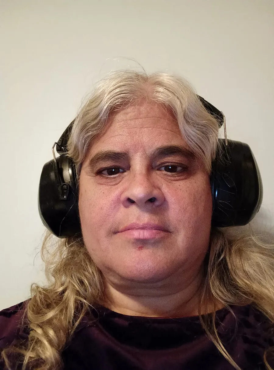 A child wearing padded ear protectors to block out loud noise