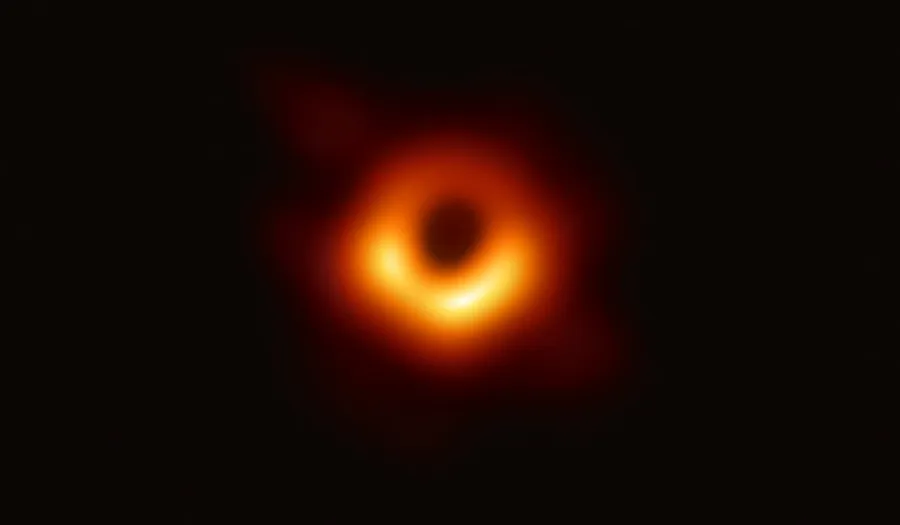 The first photograph of a black hole's dark shadow ringed by light