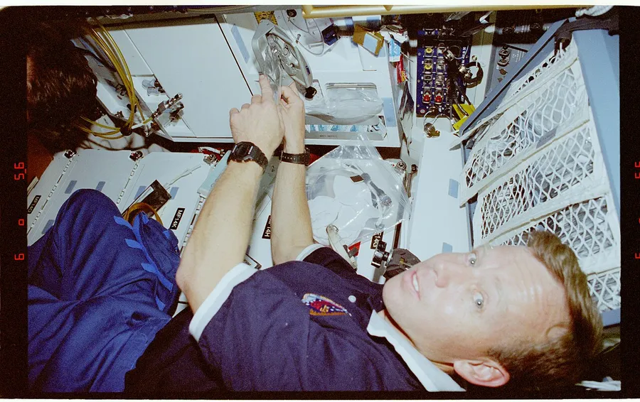 An astronaut catching floating food in microgravity on the space station