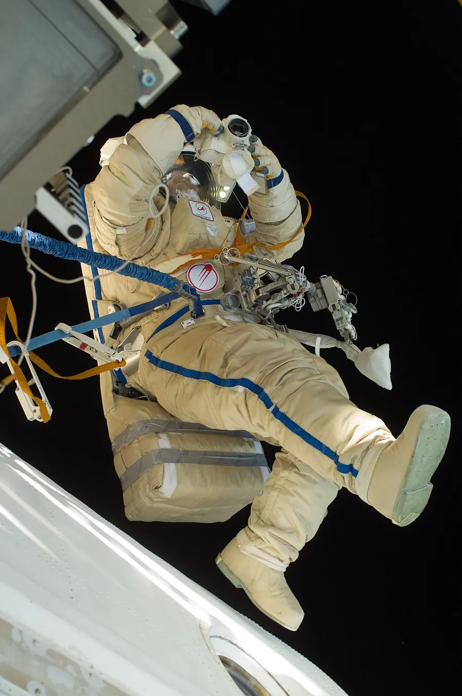 An astronaut on a spacewalk in a white spacesuit outside the station