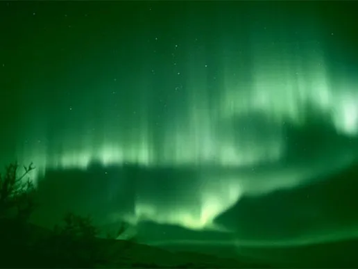 A stream of charged particles flowing outward from the Sun