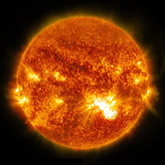 A bright solar flare erupting from the Sun's spotted surface